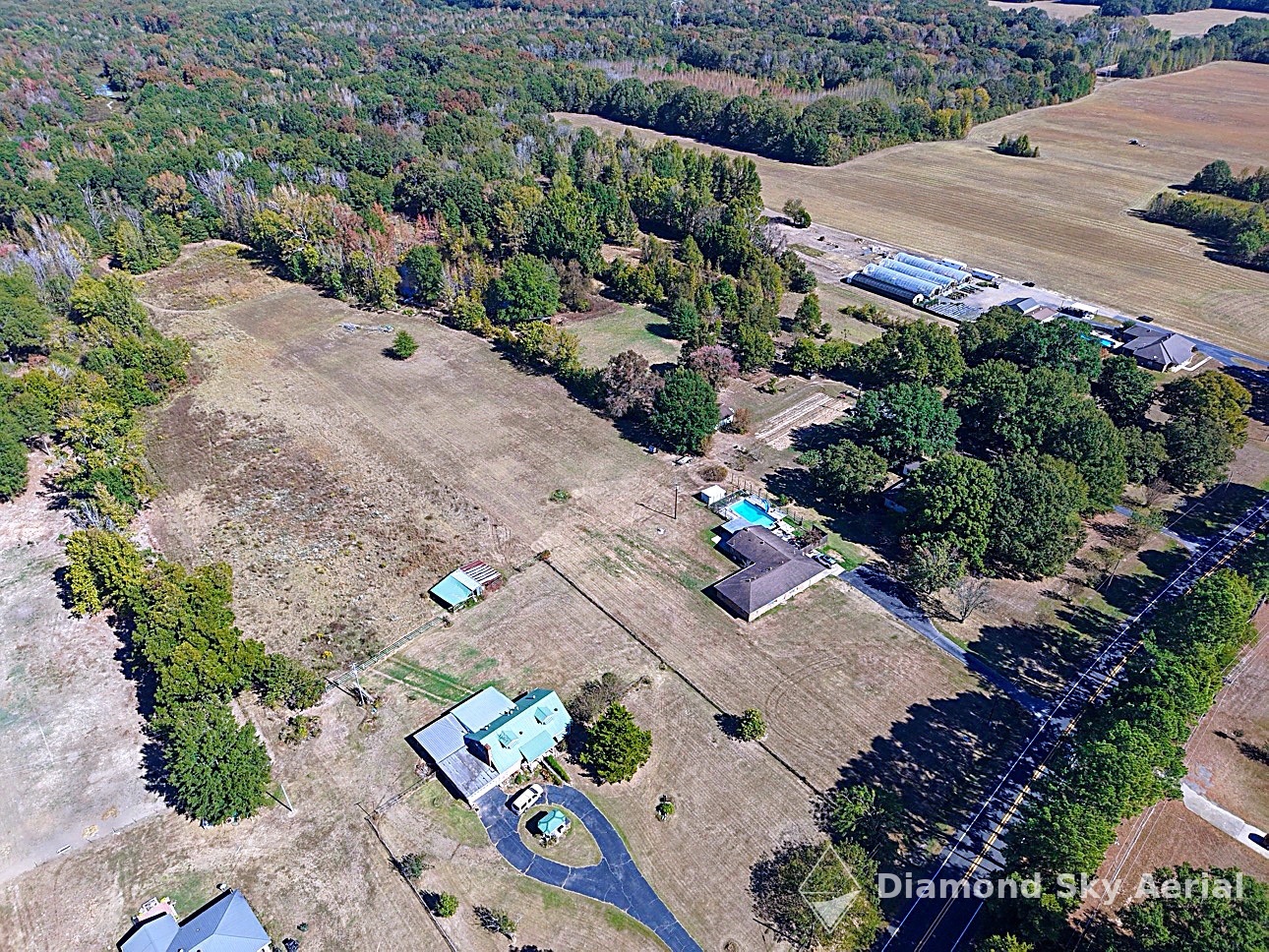 Aerial view of a rural property with a pool